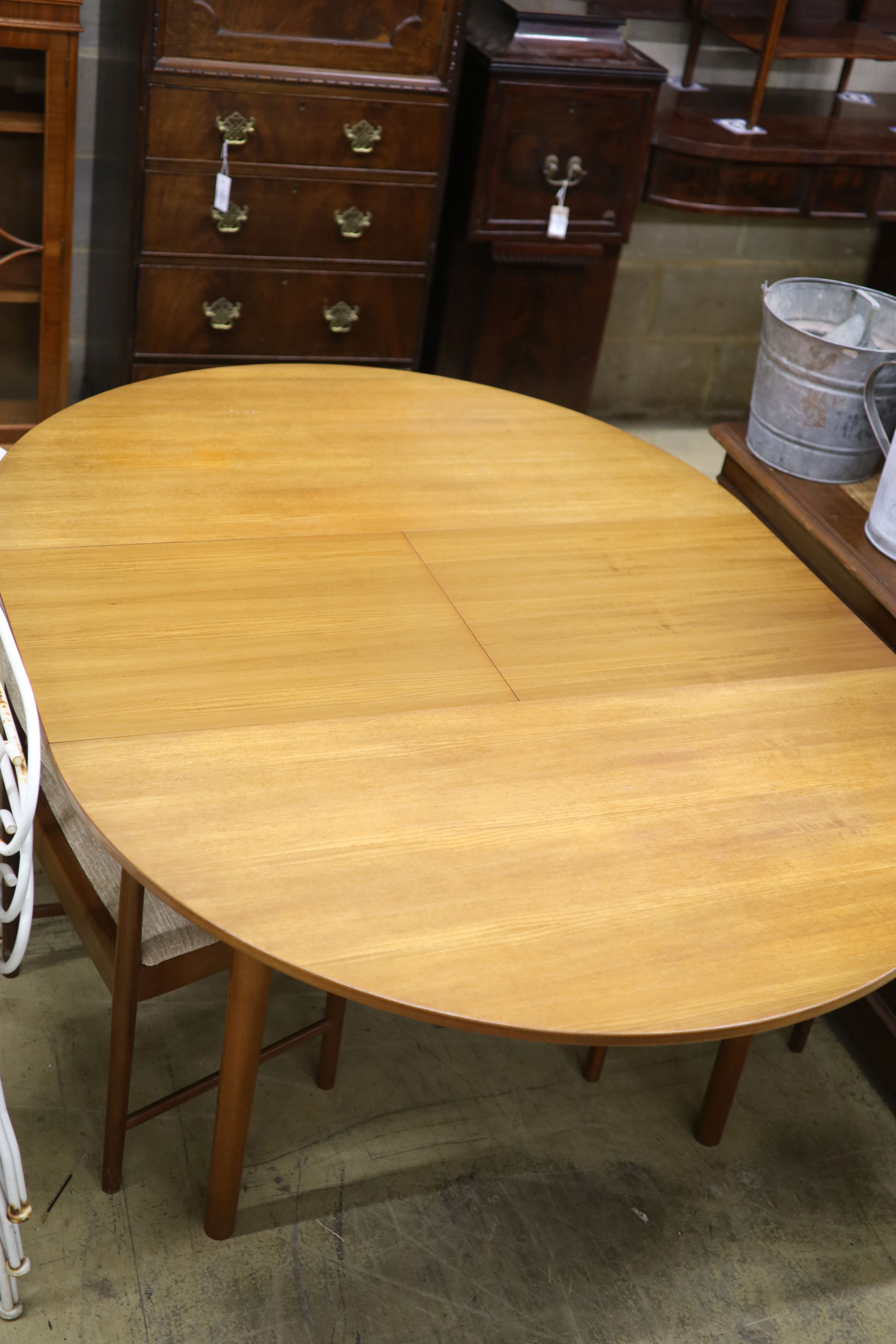 A mid century design Macintosh circular teak extending dining table and four chairs, model 9533, table width 170cm extended depth 122cm height 74cm